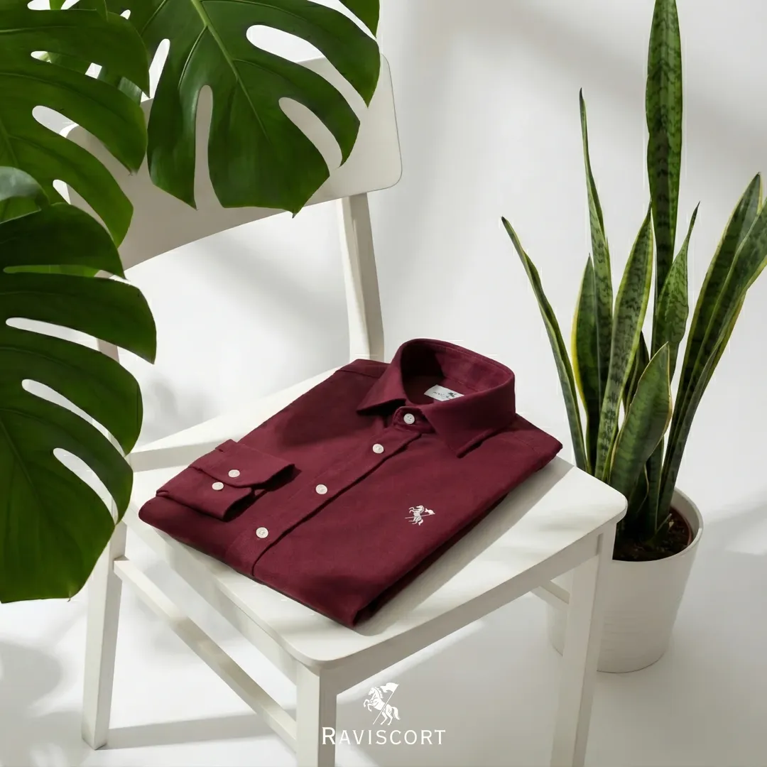 Burgundy shirt styled beside green plants